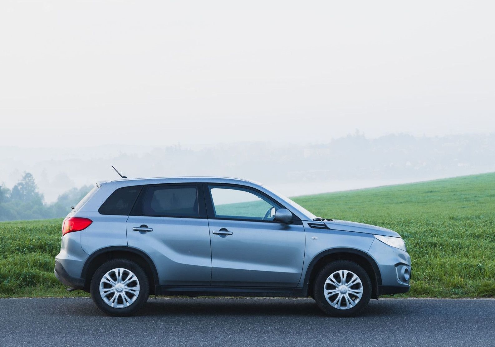 A silver SUV parked on a foggy countryside road in Zbraslavice, Czech Republic.